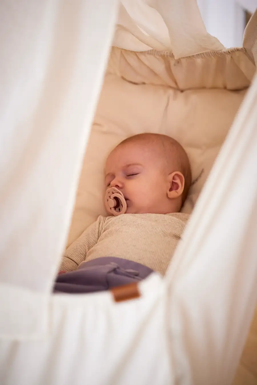 Schlafendes Baby in einer Federwiege – sanfter und geborgener Babyschlaf