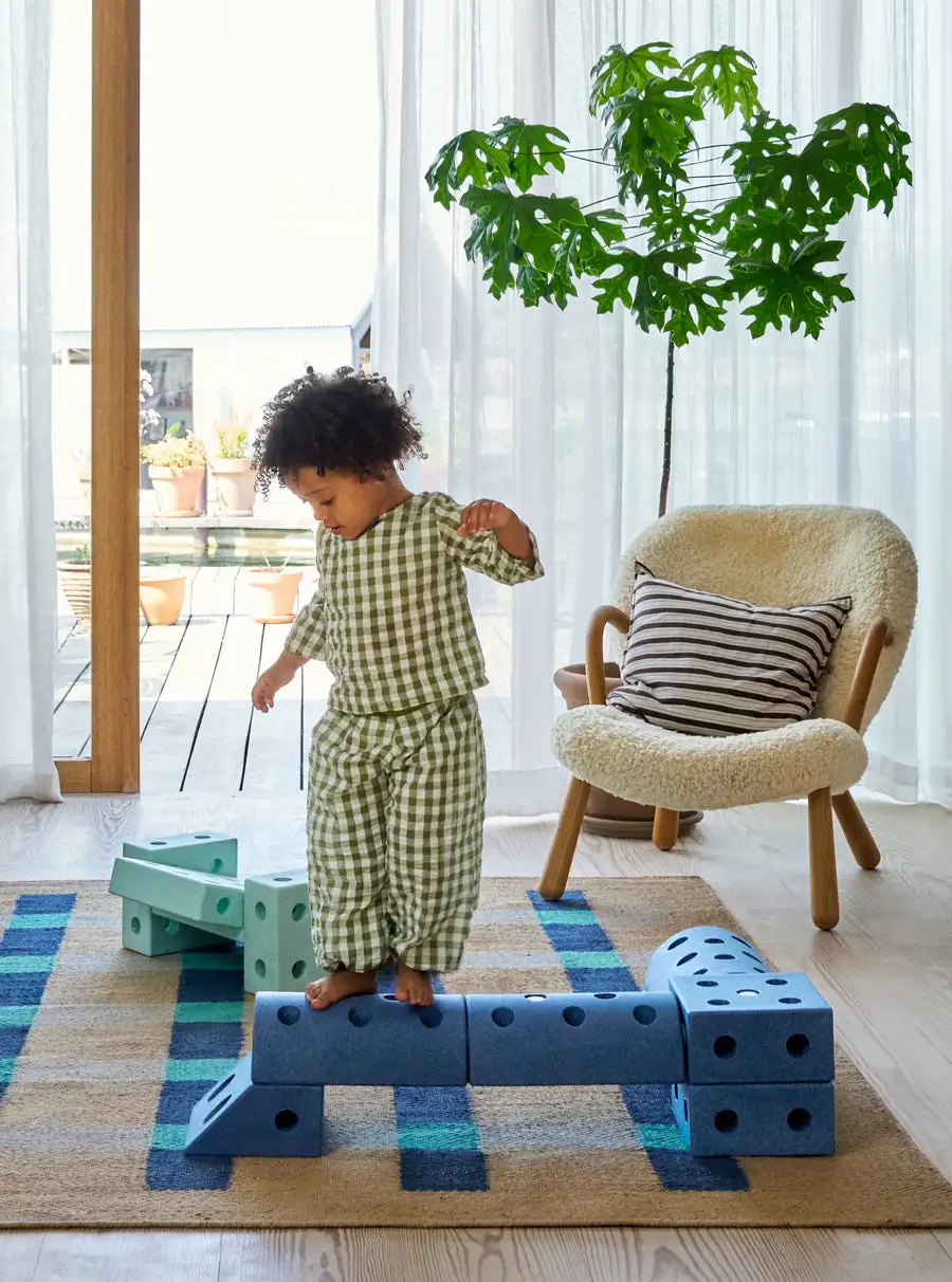 Kleinkind fördert sein Gleichgewicht auf einer Treppe aus Modu Bausteinen